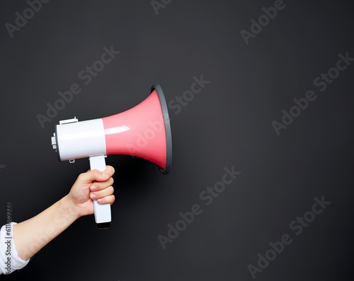 holding megaphone on color background