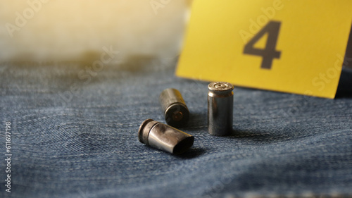 Pistol bullet shells on blur blue jeans and number four display in background, concept for criminal and investigation. soft focus
