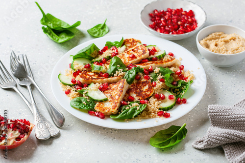 healthy halloumi cheese and couscous salad with cucumber spinach pomegranate hummus
