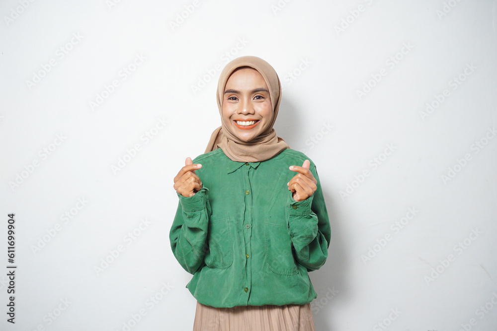 A smiling young Asian Muslim woman dressed in casual showing gesturing Korean love A smiling young Asian Muslim woman dressed in casual showing gesturing Korean love