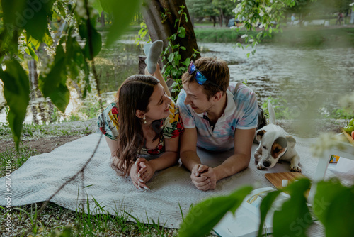 Couple in love with dog on picnic on lawn photo