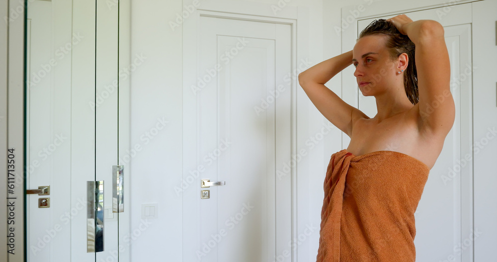Close up woman in towel standing in bedroom touch brown hair, haircare concept Close up woman in towel standing in bedroom touch brown hair, haircare concept
