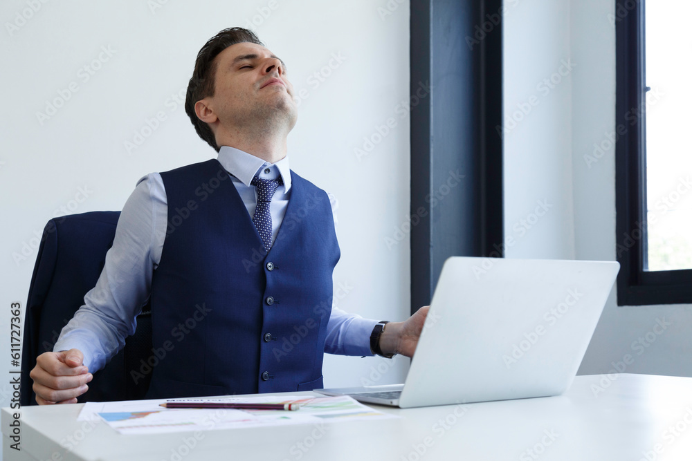 tired businessman working in office with eye strain from computer. burnout, migraine and stretch professional manager doing marketing and financial plan on laptop. office syndrome and healthcare. tired businessman working in office with eye strain from computer. burnout, migraine and stretch professional manager doing marketing and financial plan on laptop. office syndrome and healthcare.