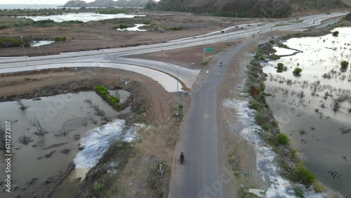 Man drives motorbike on new Highway in Lombok, Indonesia near Tanjung Aan Beach and Gerupuk Village photo