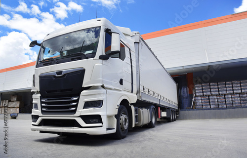 white truck in front of the warehouse, a loading truck