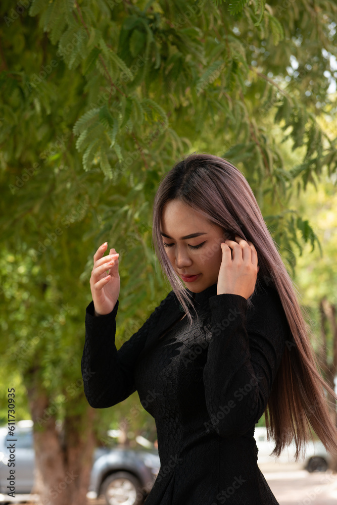 Bueaty girl brunet hair ware black dress with green forest background