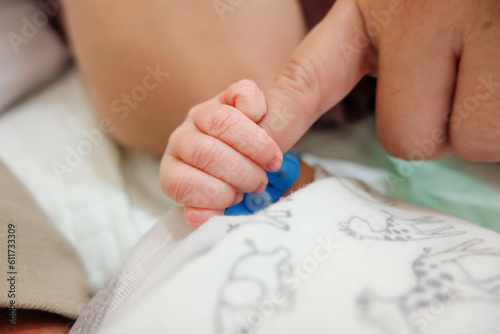 newborn's hand holds mom's finger