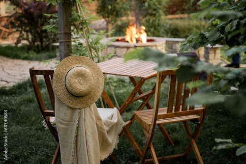 Wooden furniture in the garden against the backdrop of a fire on the patio.