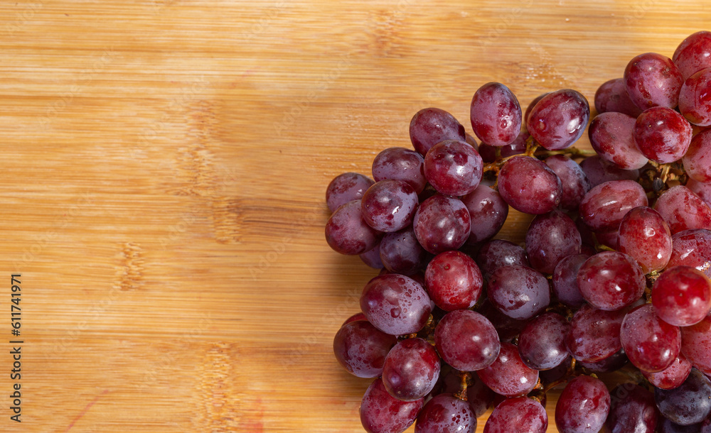bunch of eco - grapes from southafrica sable over a wood table bunch of eco - grapes from southafrica sable over a wood table