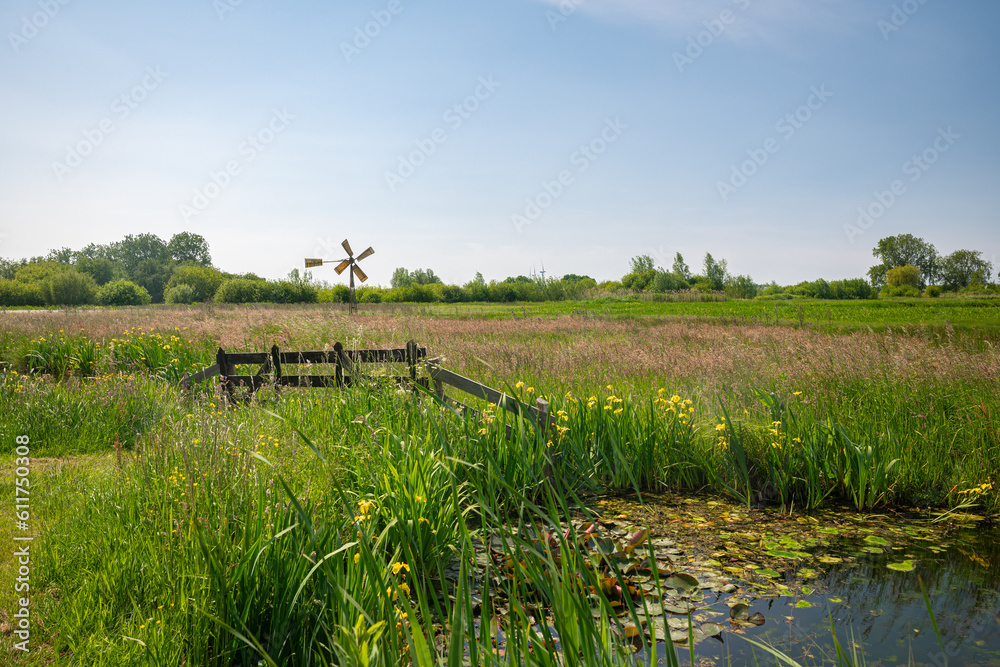 Obraz premium Idyllic view of a fence and small windmill in the Dutch polder landscape near Gouda, Holland