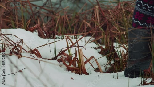 Walking in rubber boots on a wet snow and dry grass. Close up. High quality audio. ASMR style footage.