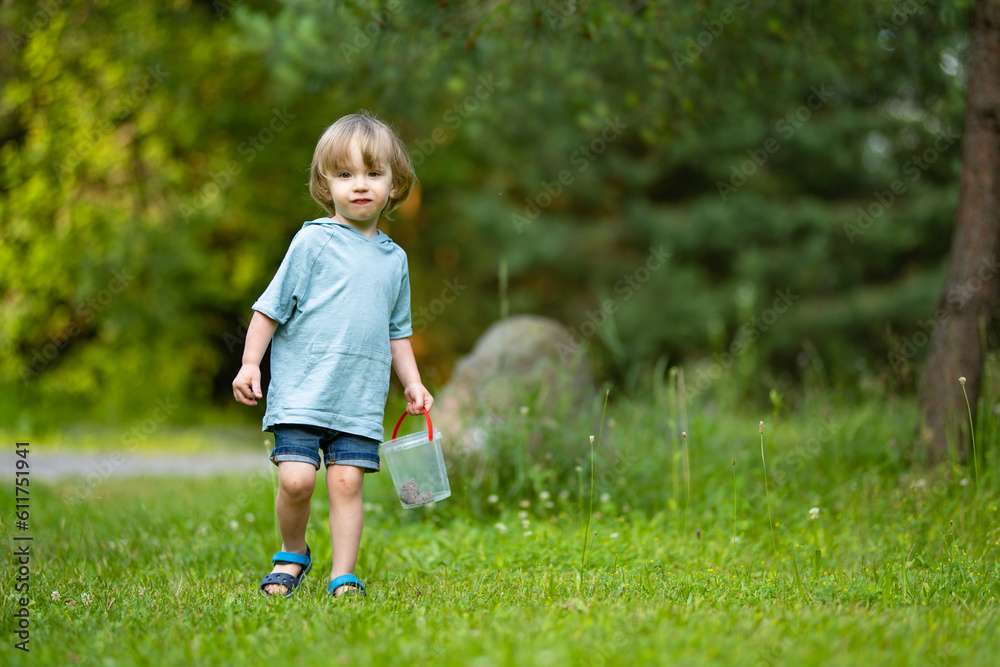Adorable toddler boy having fun outdoors on sunny summer day. Child exploring nature. Summer activities for kids.