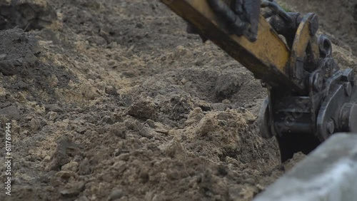 Wallpaper Mural Excavator in action at the construction site. Stock footage. Bottom view of excavator flipping the bucket of yellow color loaded with sand on blue cloudy sky background. Torontodigital.ca