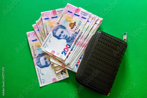 A pack of Ukrainian 200 hryvnia with a wallet on a green background photo