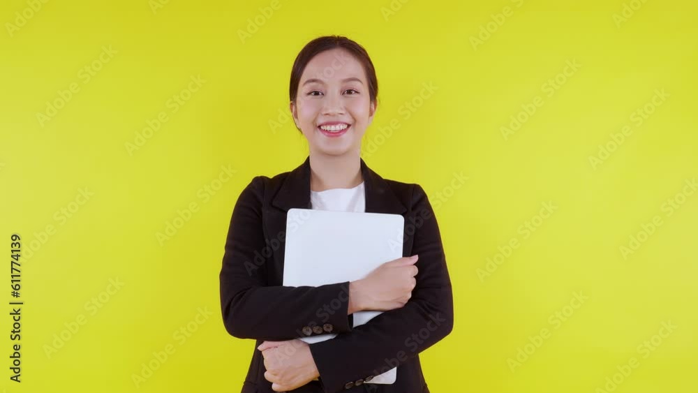 Portrait young asian businesswoman standing hug laptop computer with expression on yellow background, business woman embrace notebook and smile with happiness, female in suit or entrepreneur. Portrait young asian businesswoman standing hug laptop computer with expression on yellow background, business woman embrace notebook and smile with happiness, female in suit or entrepreneur.