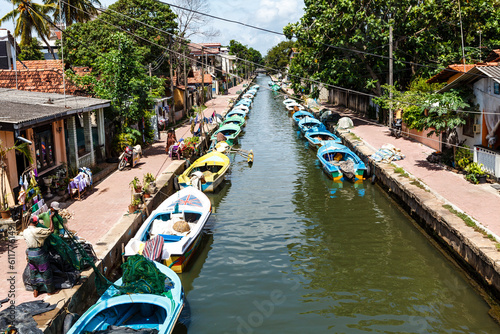 Tableau sur toile Old canal with houses and small fishing boats in Negombo, Sri Lanka, Asia