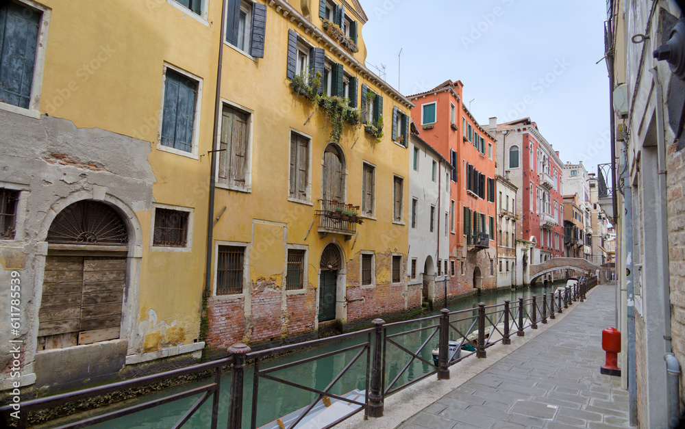 Venice Canal View with Stone Walkway and Distant Bridge