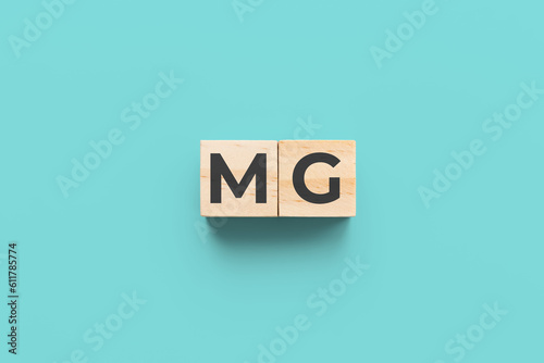 MG (Myasthenia Gravis) wooden cubes on teal background