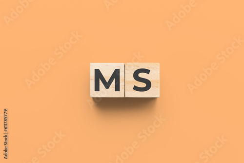 MS (multiple sclerosis) wooden cubes on orange background