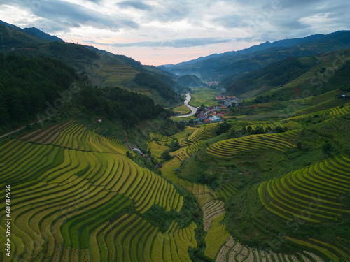 Aerial top view of fresh paddy rice terraces, green agricultural fields in countryside or rural area of Mu Cang Chai, mountain hills valley in Asia, Vietnam. Nature landscape background. © tampatra
