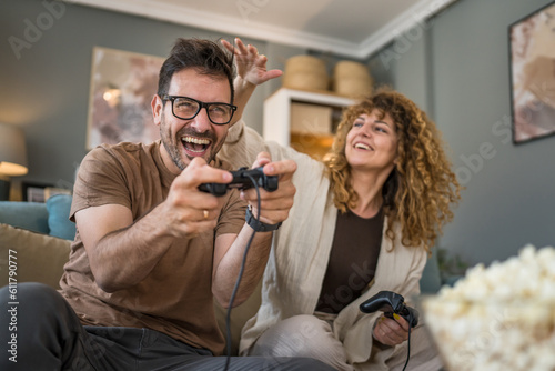 couple man and woman husband wife play console video games at home