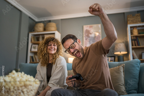 couple man and woman husband wife play console video games at home