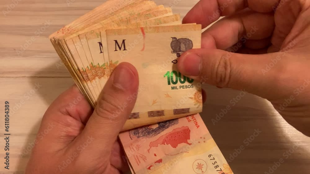hands counting money Argentine 1000 peso bills, symbol for Argentina's inflation
