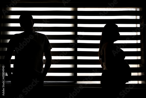pregnant couple at the backlit window. minimalist home pregnancy concept