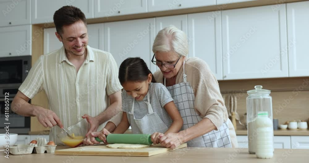 Multi generational relatives people cooking together homemade pie for holiday in kitchen. Elderly 60s grandma, grandchild and dad enjoy talk, prepare pastries on weekend at home. Ties, family recipe Multi generational relatives people cooking together homemade pie for holiday in kitchen. Elderly 60s grandma, grandchild and dad enjoy talk, prepare pastries on weekend at home. Ties, family recipe