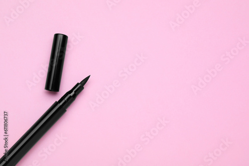 Eyeliner marker on pink background, top view with space for text. Makeup product