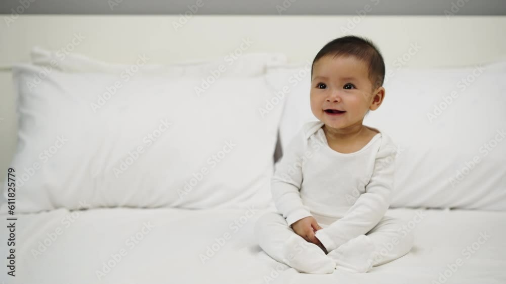 happy infant baby sitting on a bed happy infant baby sitting on a bed