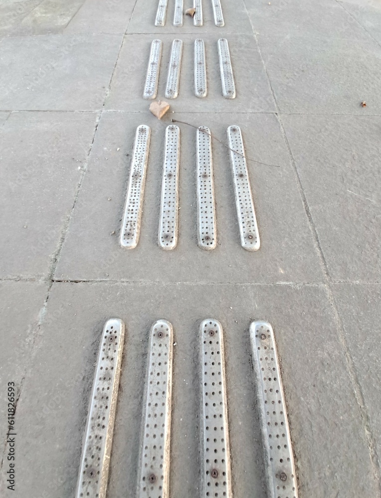 Fototapeta premium tactile warning strip for the visually impaired on the sidewalk. Tactile ground surface indicators for blind and visually impaired. Detectable warnings outside