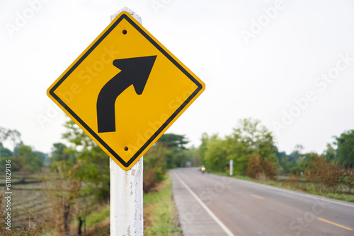 A traffic sign that is a warning sign on the right curve and has a road as a background concept background or can be used for various advertisements.