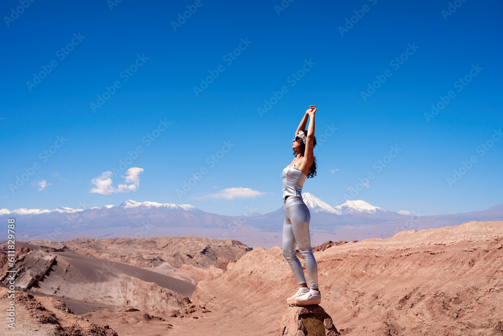 beauty portrait adult woman posing with arms above her head in the Valley of the Moon in San Pedro de Atacama beauty portrait adult woman posing with arms above her head in the Valley of the Moon in San Pedro de Atacama