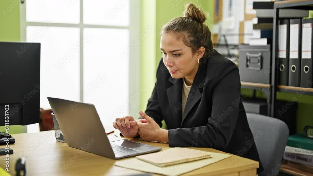 Young beautiful hispanic woman business worker suffering for backache working at office Young beautiful hispanic woman business worker suffering for backache working at office
