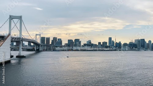 レインボーブリッジと芝浦周辺のビル群の夕景と通過する船舶