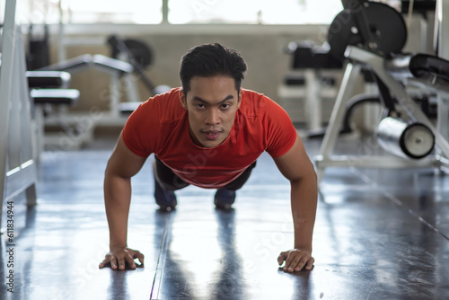 Muscular Asian young athlete man pushs up training on floor at gym