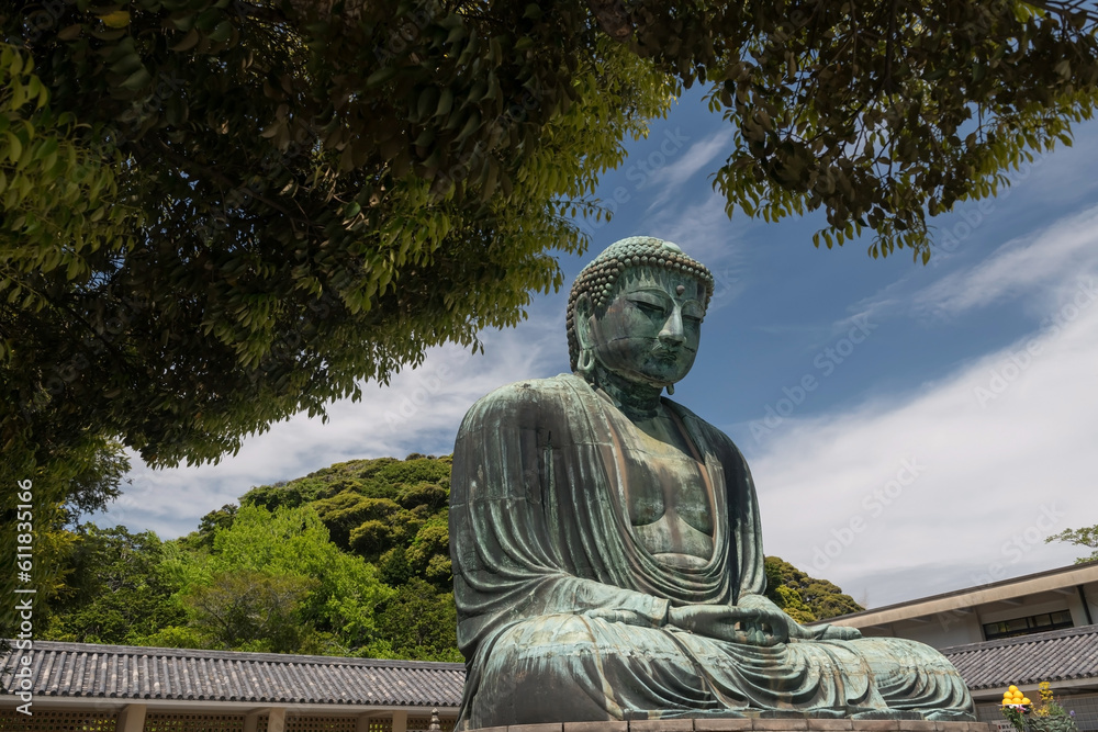 Obraz premium Kamakura Daibutsu great Buddha with green leaf in sunny day