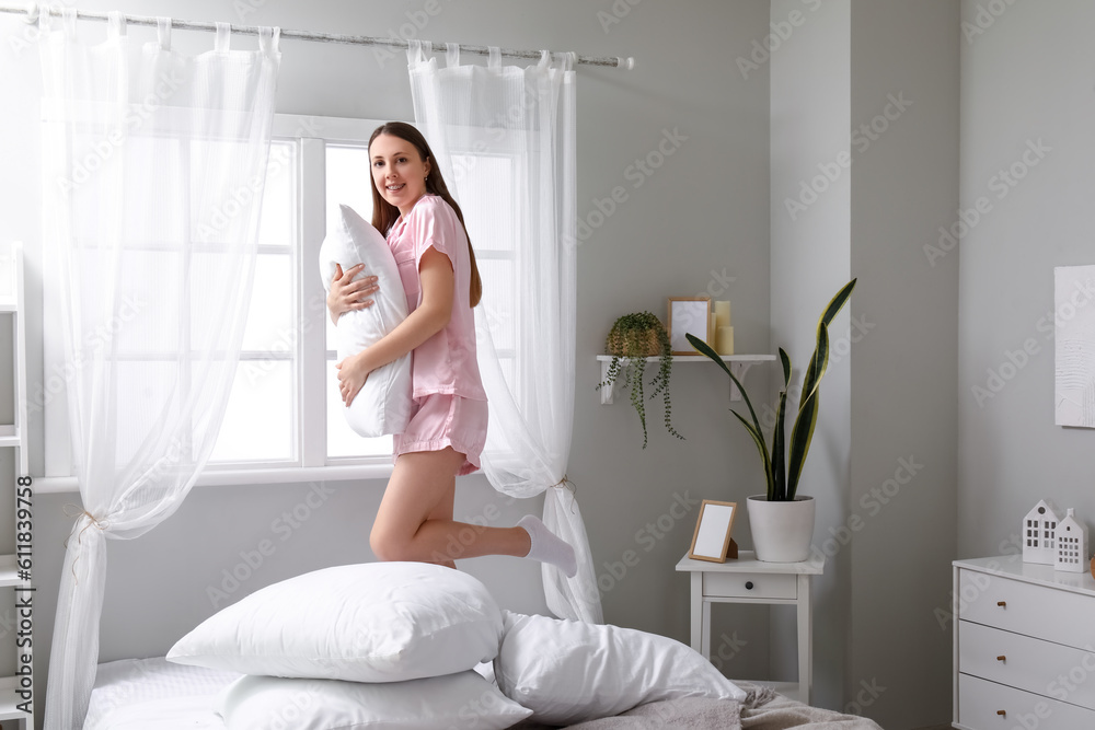 Pretty young woman with soft pillow in bedroom Pretty young woman with soft pillow in bedroom