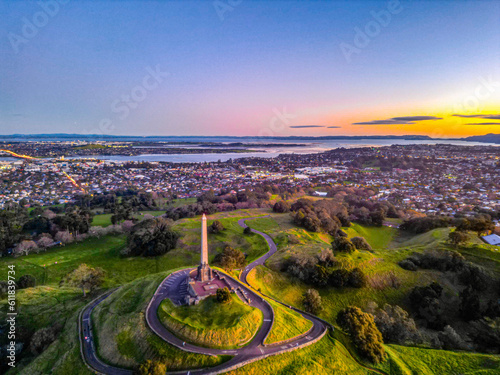 Monument on One Tree Hill, in Cornwall Public Park, Auckland. Sunset colours and city neighbourhoods and water create a background. 
