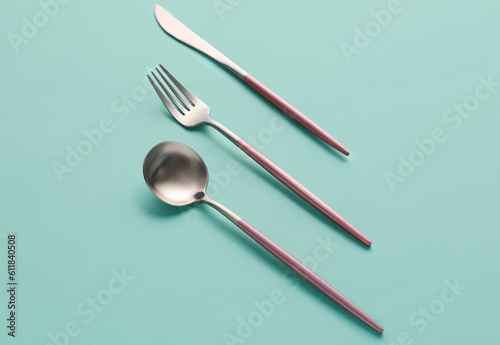 Stylish cutlery on green background