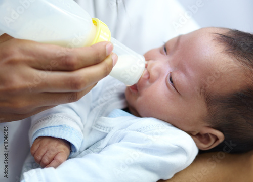 Baby with cleft lip, milk and mom feeding from bottle for nutrition, health and wellness. Formula, newborn and hand of mother feed child for development, growth or healthy diet, food or lunch at home