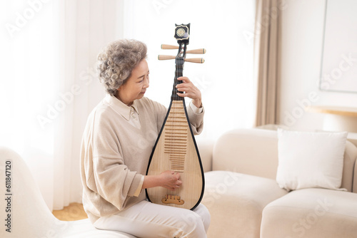 Senior woman plucking Chinese lute photo