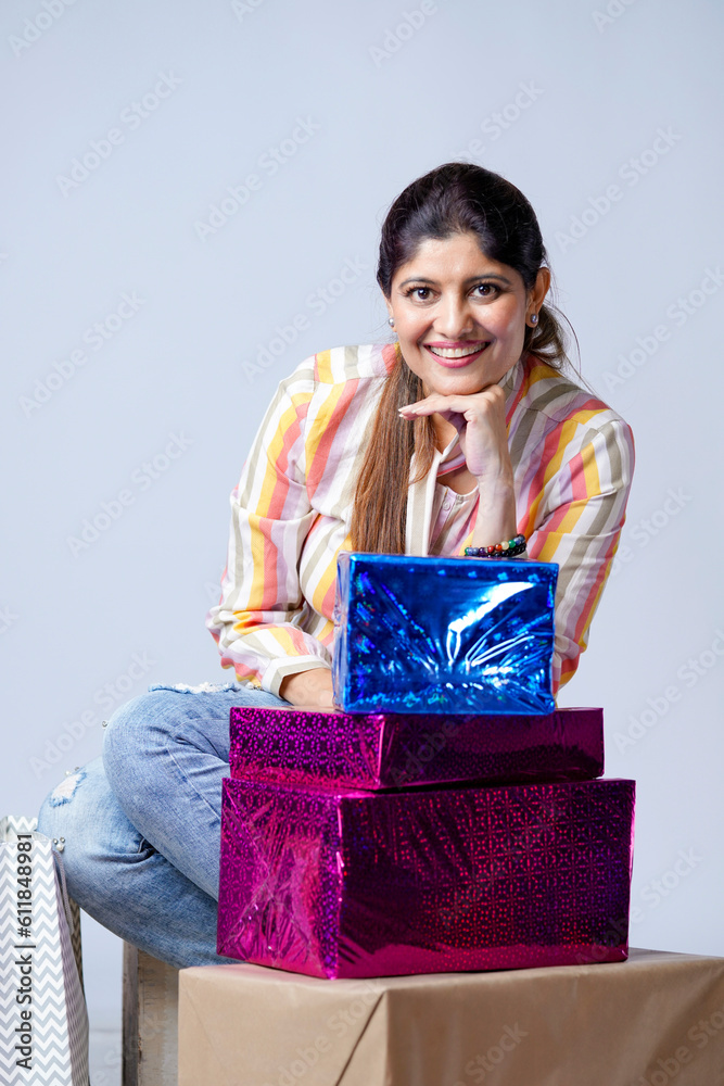 Indian woman sitting with gift boxes on white background. Indian woman sitting with gift boxes on white background.