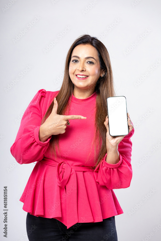 Naklejka premium Indian woman showing smartphone screen on white background.