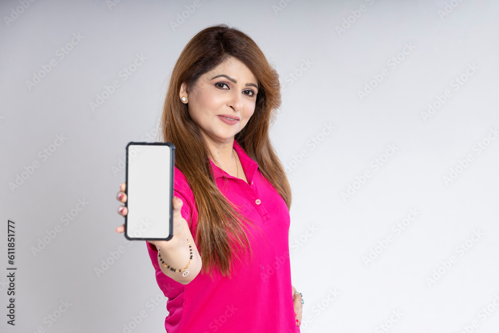 Indian woman standing and showing smartphone screen on white background. Indian woman standing and showing smartphone screen on white background.