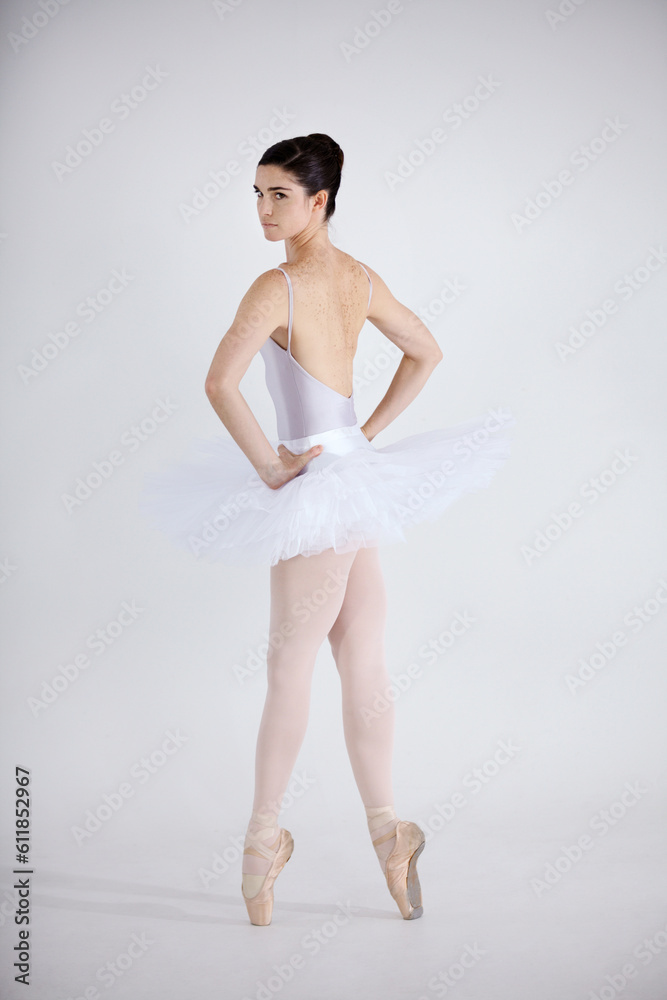 Portrait, dance and ballet with a woman in studio on a white background for theatre performance rehearsal or recital. Art, creative and back with a young ballerina or dancer standing hands on hips Portrait, dance and ballet with a woman in studio on a white background for theatre performance rehearsal or recital. Art, creative and back with a young ballerina or dancer standing hands on hips
