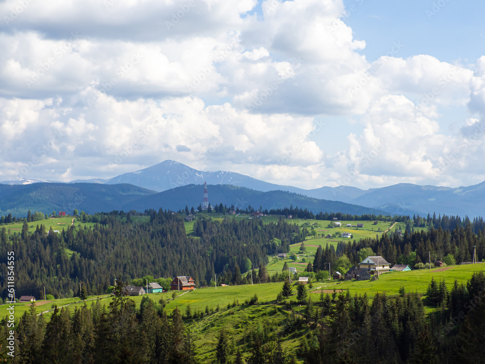 Carpathian landscape with cloudy sky. Green meadows in mountains near forest. Lifestyle in the Carpathian region. Ecology protection concept. Explore the beauty of the world.