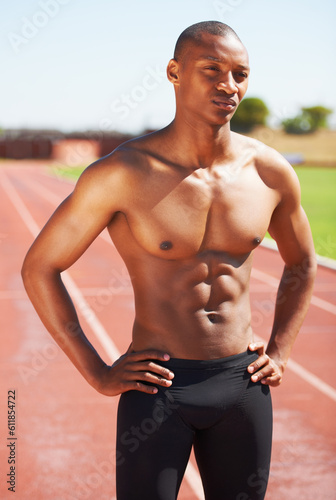 Body  mindset and topless man at a race track for training  fitness and sport  cardio and speed running practice. Stadium  start and African male runner serious  focus and ready for performance run