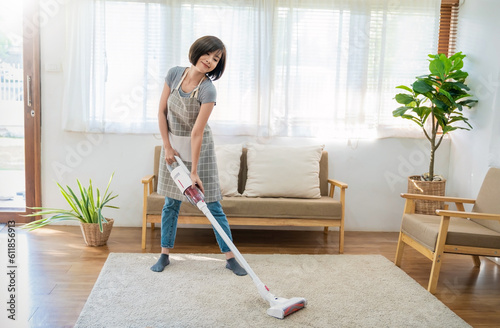 Portrait of young woman housewife hands holding mop cleaning floor with smart object technology in modern living room. Daily routine cleaning. Domestic housework service concept